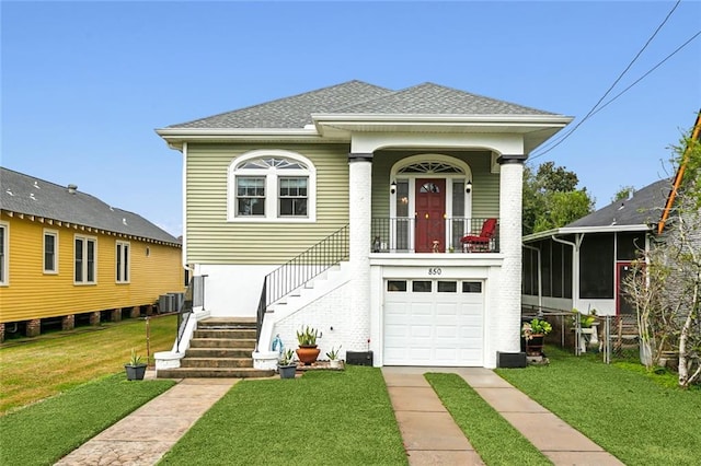 view of front of home with central air condition unit, a sunroom, a front yard, and a garage