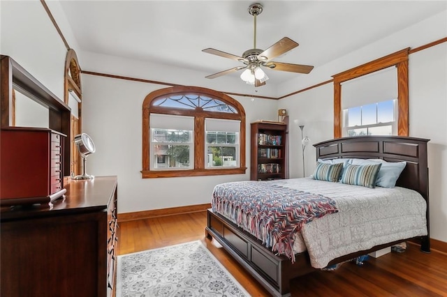 bedroom featuring multiple windows, hardwood / wood-style flooring, and ceiling fan