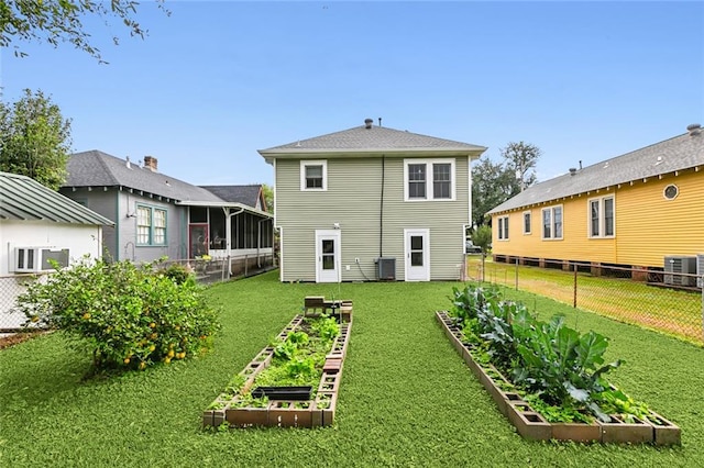 back of house featuring a lawn and central air condition unit