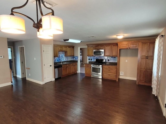 kitchen with dark wood-type flooring, sink, appliances with stainless steel finishes, and tasteful backsplash