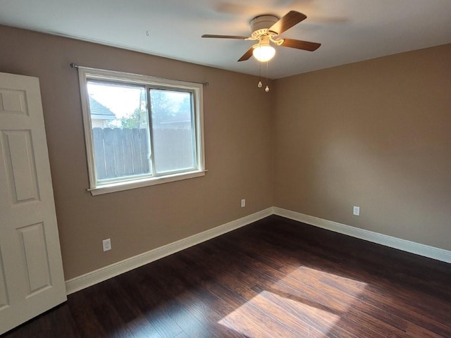 empty room with ceiling fan and dark hardwood / wood-style floors