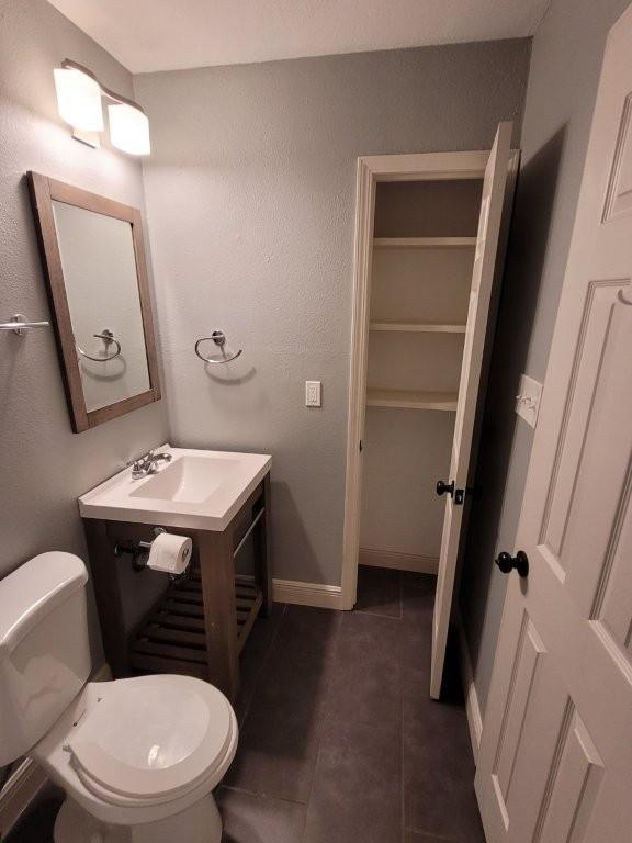 bathroom with tile patterned flooring, vanity, and toilet