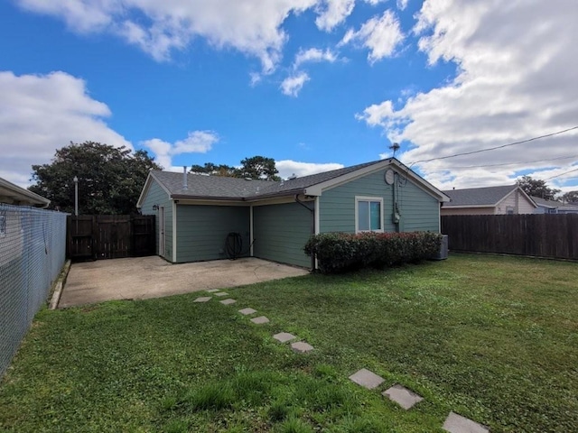 back of house featuring a lawn and a patio