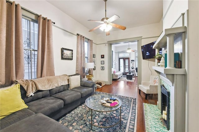 living room featuring a high end fireplace, dark wood-type flooring, ceiling fan, and ornate columns