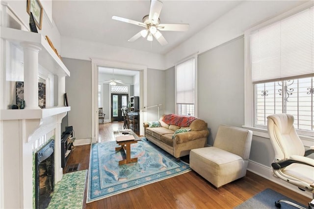 living room with ceiling fan, dark hardwood / wood-style floors, and a wealth of natural light