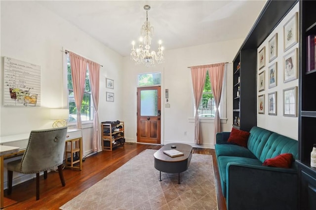 living area with dark wood-type flooring, a healthy amount of sunlight, and an inviting chandelier