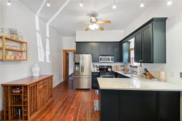 kitchen with dark wood-type flooring, sink, light stone counters, appliances with stainless steel finishes, and kitchen peninsula