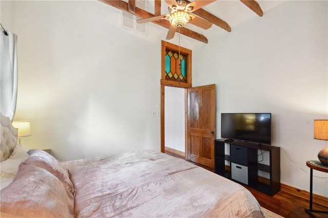 bedroom with ceiling fan, dark hardwood / wood-style floors, and beamed ceiling