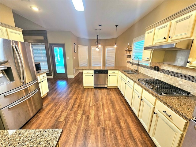 kitchen featuring decorative light fixtures, stainless steel appliances, sink, kitchen peninsula, and cream cabinetry