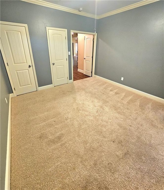 unfurnished bedroom featuring ornamental molding and carpet flooring