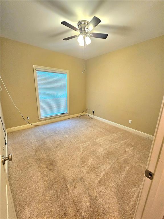 unfurnished room with carpet flooring and ceiling fan