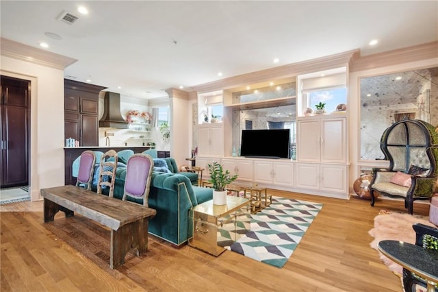 living room featuring light wood-type flooring and crown molding