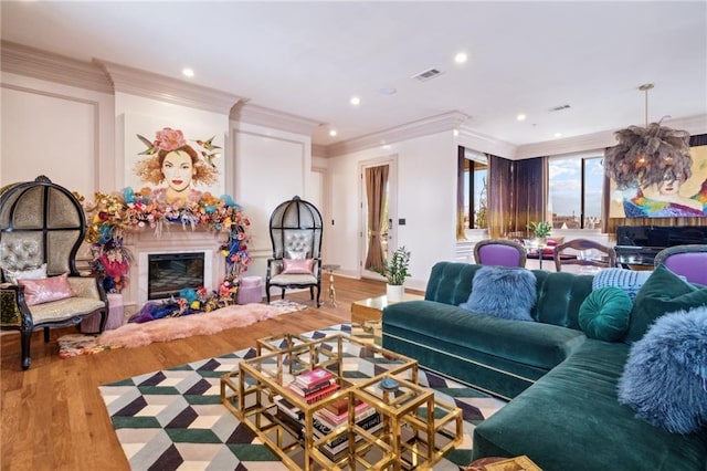 living room with light wood-type flooring and crown molding