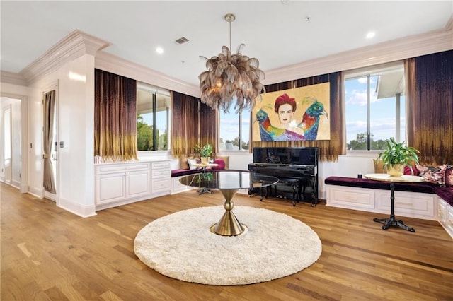 misc room featuring light hardwood / wood-style floors, ornamental molding, and a chandelier