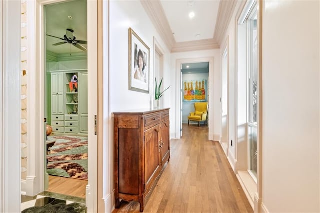 corridor with light hardwood / wood-style floors, plenty of natural light, and crown molding