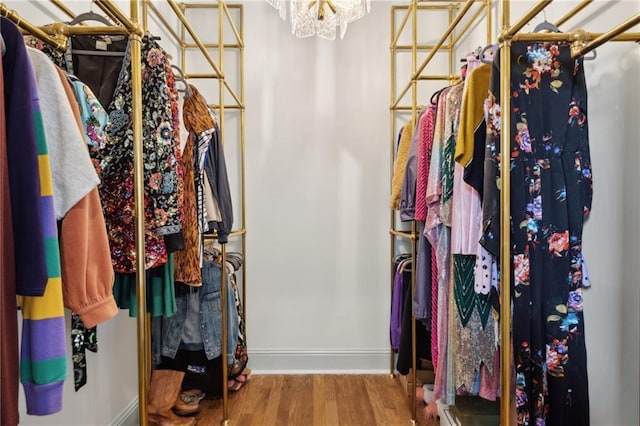 spacious closet featuring hardwood / wood-style floors and a notable chandelier