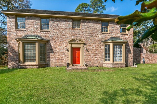 colonial inspired home featuring a front lawn