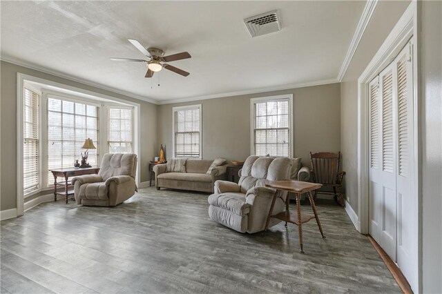 dining space with a healthy amount of sunlight, dark hardwood / wood-style flooring, an inviting chandelier, and crown molding