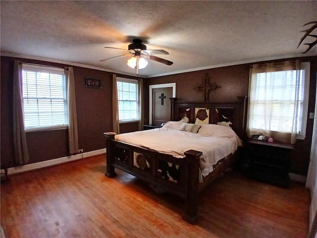 bedroom featuring a textured ceiling, ceiling fan, wood-type flooring, and crown molding