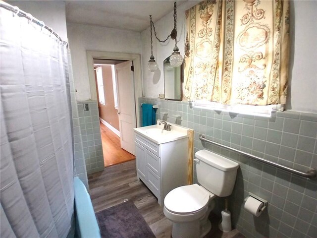 bathroom featuring wood-type flooring, vanity, toilet, and an enclosed shower