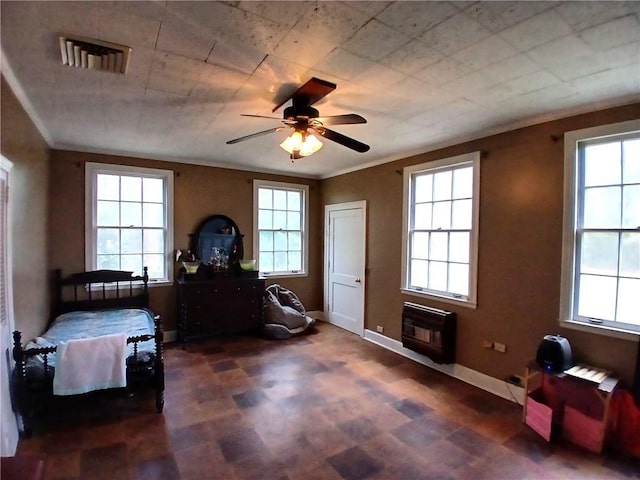 interior space with ceiling fan, ornamental molding, and heating unit