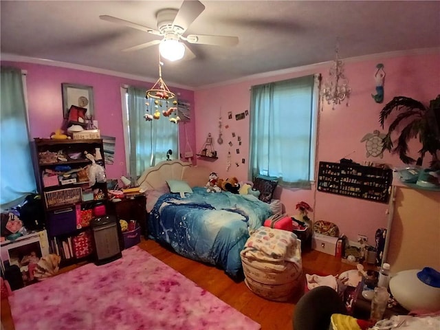 bedroom featuring hardwood / wood-style flooring, ceiling fan, and crown molding