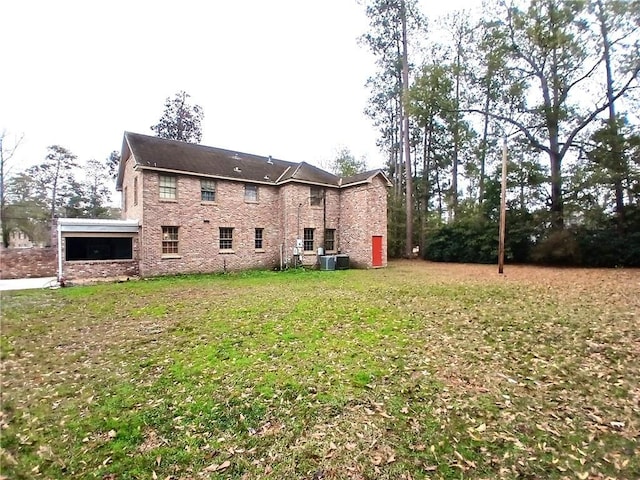 back of property featuring a lawn and central AC