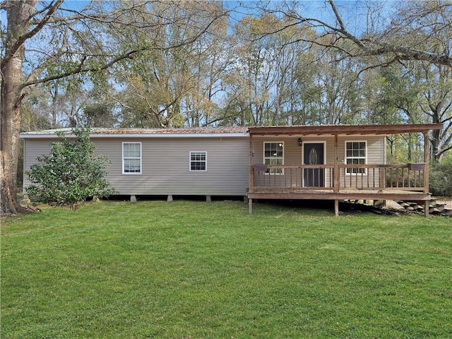 rear view of house featuring a lawn and a wooden deck