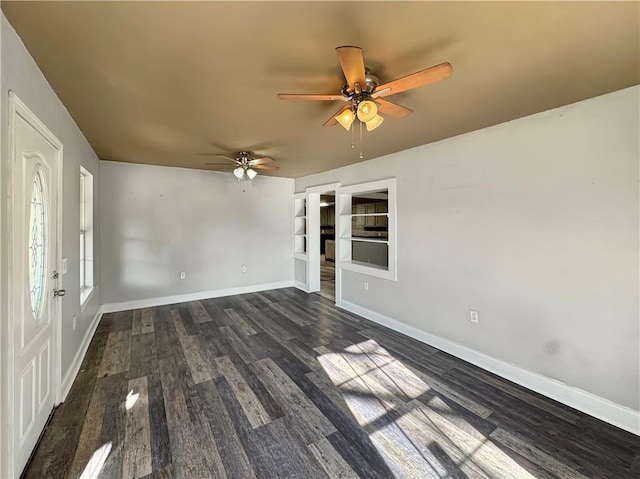 empty room with ceiling fan and dark hardwood / wood-style flooring