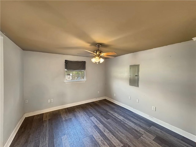 unfurnished room with electric panel, ceiling fan, and dark hardwood / wood-style floors