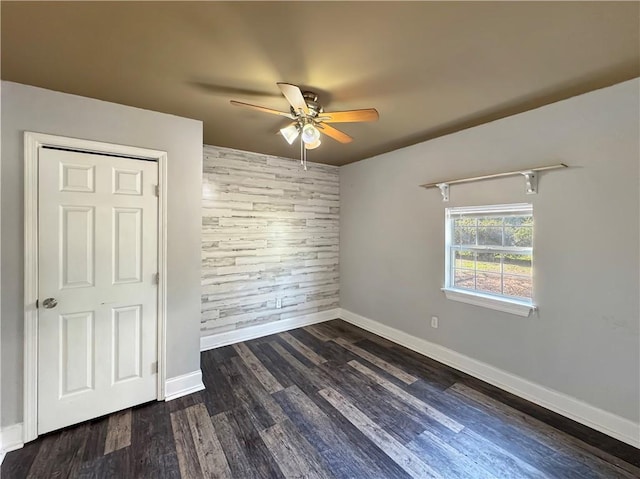 unfurnished bedroom featuring dark hardwood / wood-style flooring, a closet, and ceiling fan