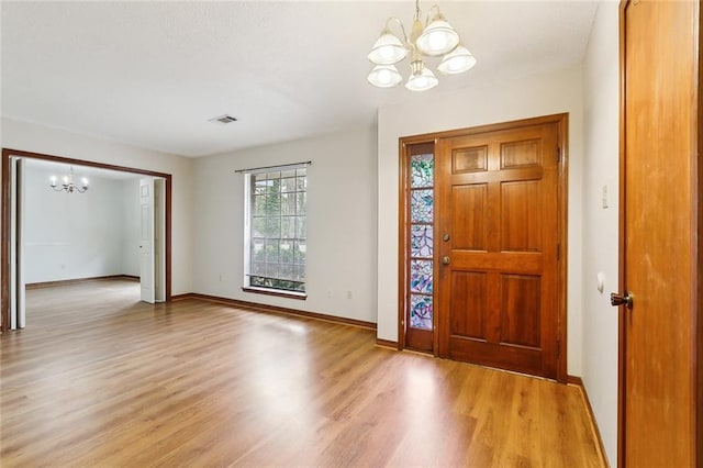 foyer entrance featuring light wood-type flooring and an inviting chandelier