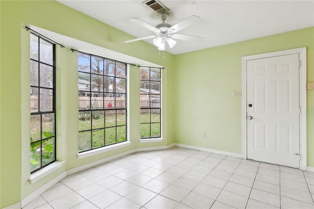 tiled empty room featuring ceiling fan