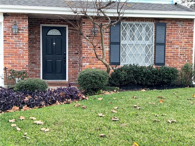 doorway to property with a lawn