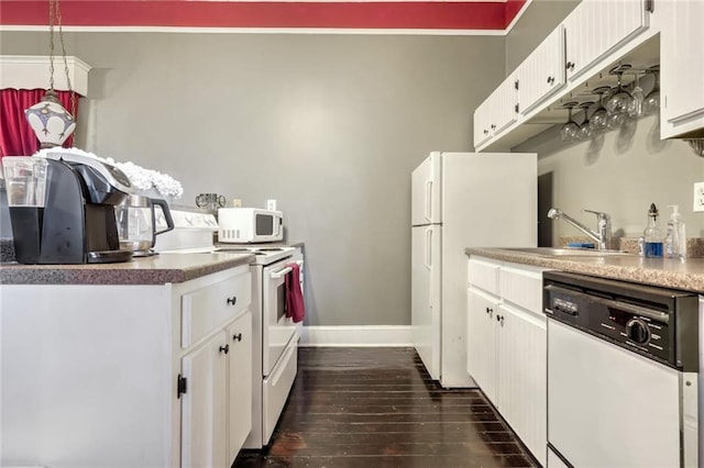 kitchen with white cabinetry, sink, dark hardwood / wood-style floors, pendant lighting, and white appliances