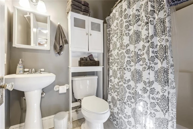 bathroom with tile patterned flooring, toilet, and walk in shower