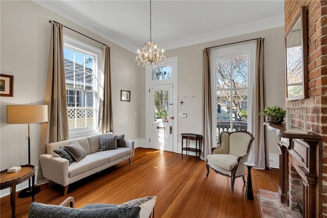 living area with hardwood / wood-style flooring, crown molding, and a notable chandelier