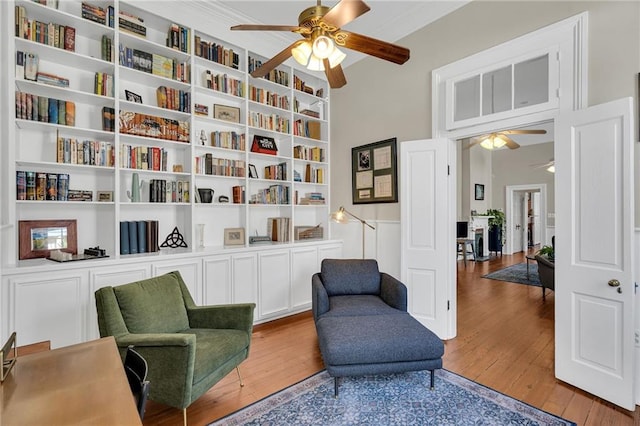 living area featuring hardwood / wood-style floors, ceiling fan, and built in features