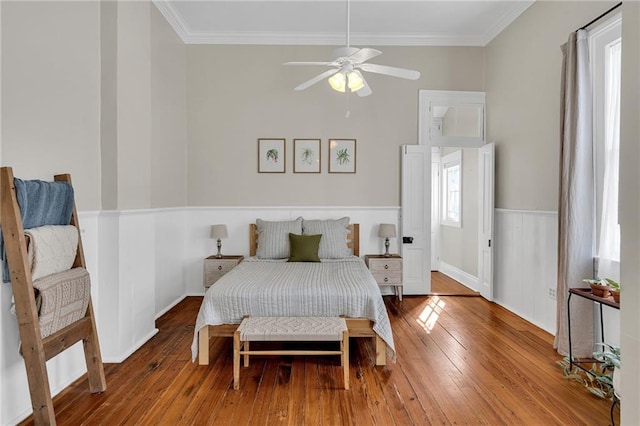 bedroom with ceiling fan, crown molding, and hardwood / wood-style flooring