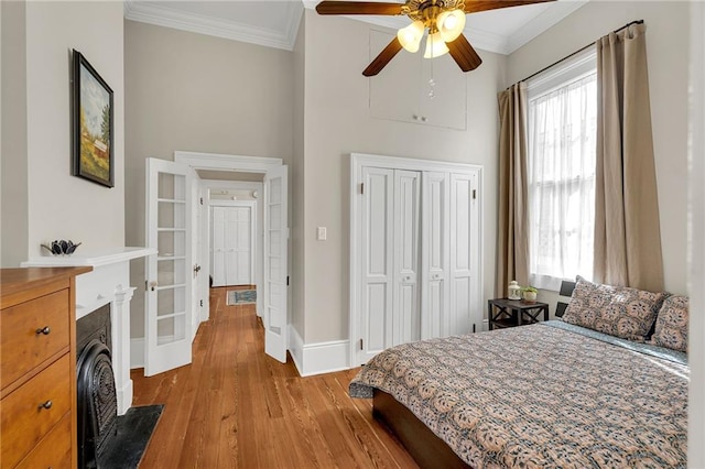 bedroom featuring ornamental molding, a closet, ceiling fan, and light hardwood / wood-style floors