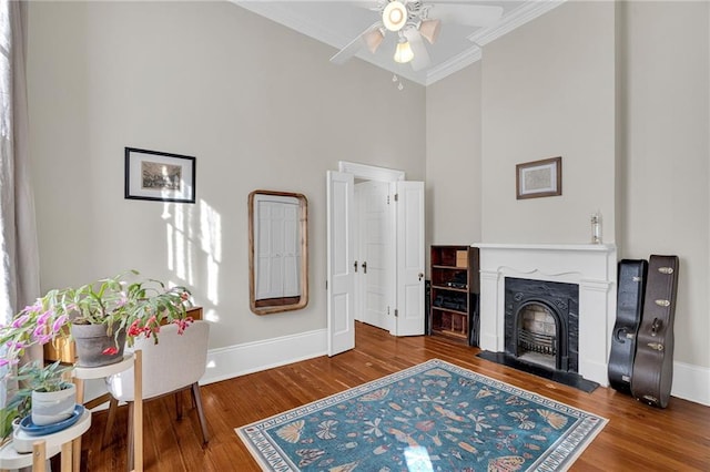 living room featuring ceiling fan, hardwood / wood-style floors, and crown molding