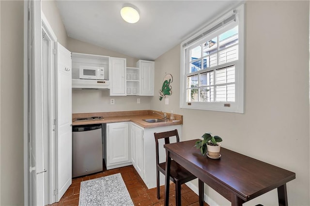 kitchen featuring sink, white cabinets, stainless steel dishwasher, and vaulted ceiling