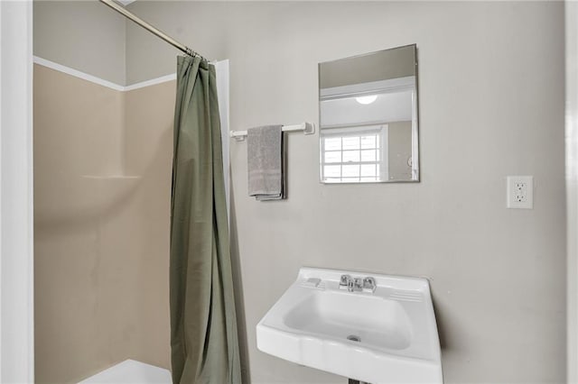 bathroom featuring a shower with shower curtain and sink