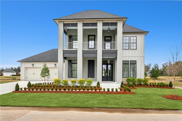 view of front of property with a front yard, french doors, a balcony, and a garage