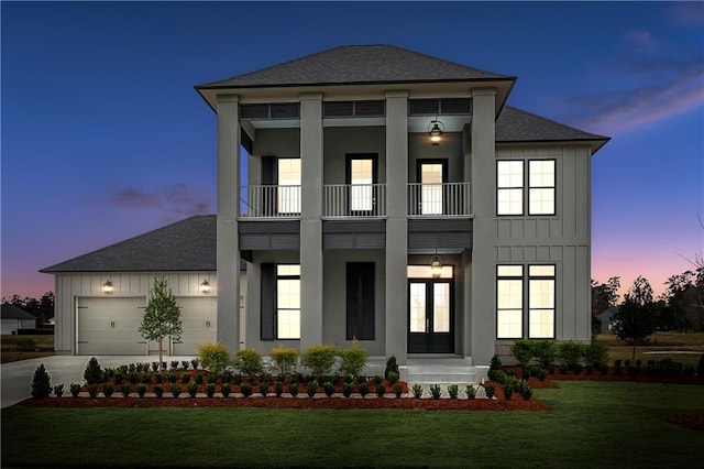 view of front of home with a lawn, a balcony, and a garage