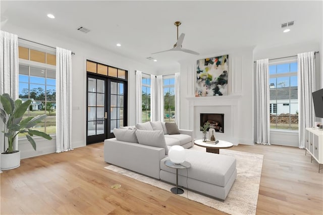 living room featuring ceiling fan, light hardwood / wood-style floors, and french doors