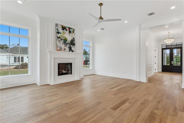 unfurnished living room with french doors, light hardwood / wood-style floors, ceiling fan, and ornamental molding