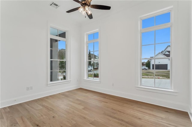 empty room with ceiling fan and light hardwood / wood-style floors