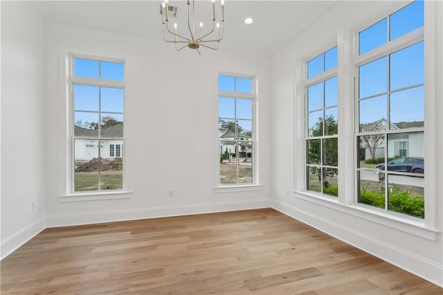 interior space with light hardwood / wood-style flooring, an inviting chandelier, and a wealth of natural light