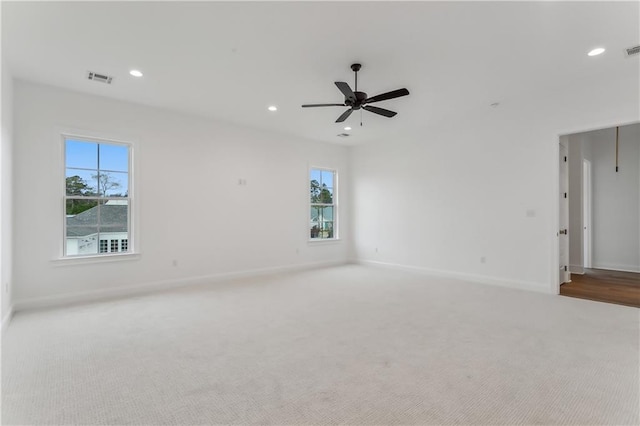 carpeted spare room with ceiling fan